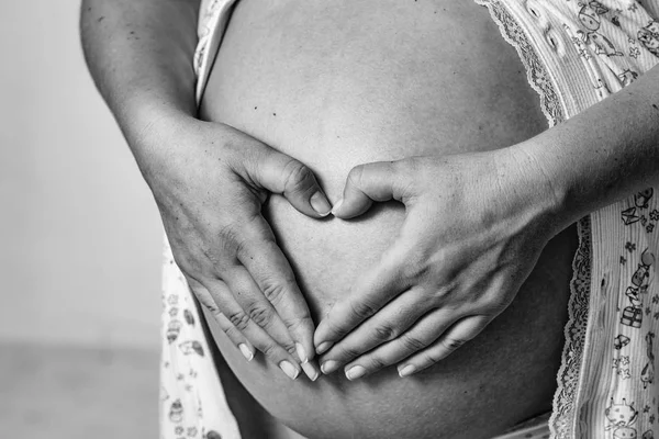 La maternité. Les mains féminines font cœur — Photo