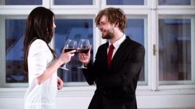 Genç romantik çift bardak kırmızı şarap ile kutluyor. Romantik Çift kırmızı şarap içme. Güzel genç çift bardak kırmızı şarap ile