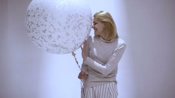 Una joven jugando con un globo. Hermosa mujer feliz joven en fiesta de cumpleaños — Vídeos de Stock