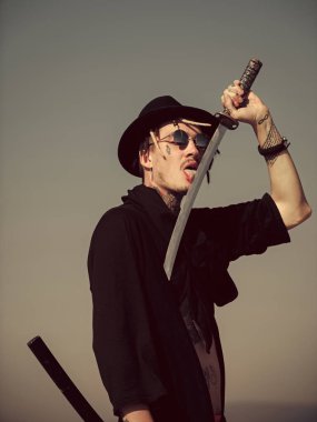 Savunma, güç, şeref, güç. Adam yalama metal blade gri gökyüzü üzerinde kılıç