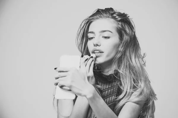 Retrato de beleza de moda. Menina colocar batom nos lábios com espelho do telefone, nova tecnologia . — Fotografia de Stock