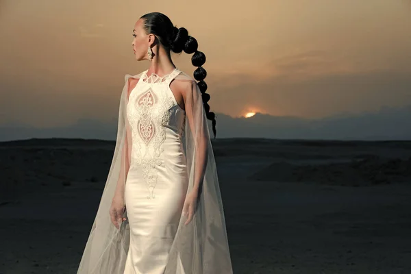 时尚美肖像 穿着婚纱和面纱的女人 在沙漠日落的女孩摆姿势 在沙丘上的新娘在山上的风景 蜜月旅行的概念 暑假和假期 — 图库照片
