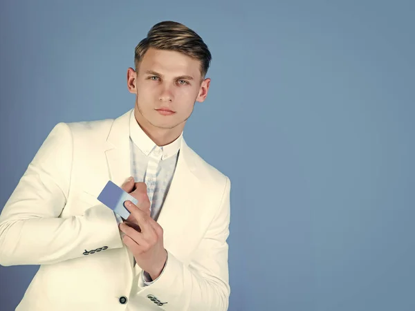 Un hombre con tarjeta de crédito. Empresario posando en chaqueta blanca y camisa — Foto de Stock