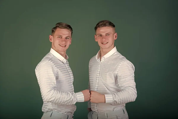 Брати-близнюки підтримують один одного. Щасливі чоловіки кулак стукає — стокове фото