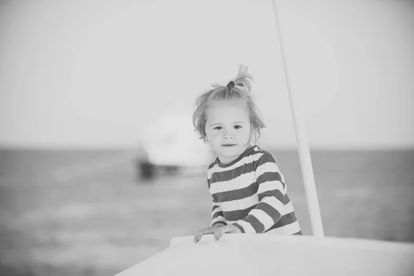 Kind aan zee in een boot. Zomer reis en vakanties. — Stockfoto