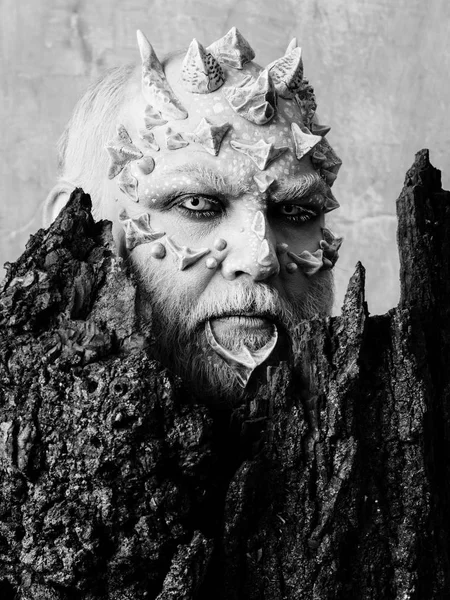 Spirit of the forest. Man with dragon skin and bearded face