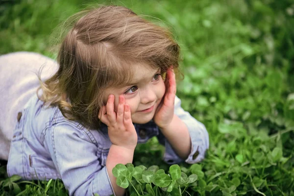 Gyermek játszik bújócskát. Aranyos gyermek mosolyog a zöld fű pázsit — Stock Fotó