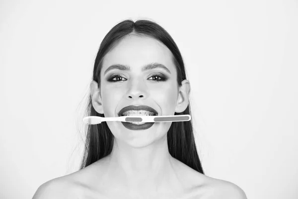 Limpieza de los dientes. chica con dientes frenos y cepillo, tiene maquillaje de moda —  Fotos de Stock