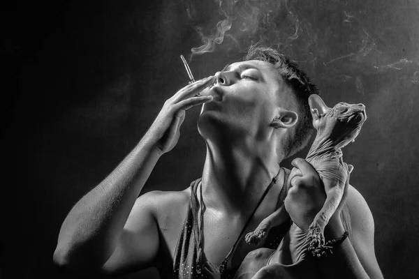 Male fashion portrait. Smoking guy and Sphynx cat — Stock Photo, Image