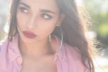 O sizin için bir sır olduğunu. Şehvetli kırmızı dudaklar makyaj kadınla. Arap kadın uzun saçlı güneşli üzerinde açık. Güzellik kız seksi bakışla. Seksi manken küpeli