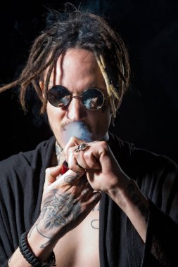 Hippi sigara içen güneş gözlüğü ve çıplak göğüs dreadlocks ile