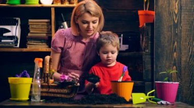 Anne ile oğlu bitki çiçek renkli tencere. Mutlu bir aile birlikte vakit. Mutlu yaz gün.