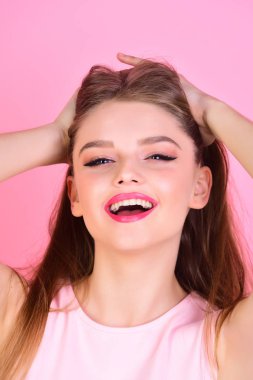Kuaför ve güzellik salonu. Moda bakmak kavramı. Pembe bir arka plan üzerinde uzun saçlı seksi kadın. kız makyaj ve sağlıklı saç. Makyaj yumuşak deri ile şehvetli modeli için. Seksi hissediyor.