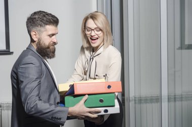 İşadamı işkadını bağlayıcı Office taşımak için yardımcı olur. Kadın ve adam ile ağıl. Sakallı adam ve belgeler ile seksi kız. Office aşk ve flört kavramı. İş işbirliği ve ekip çalışması