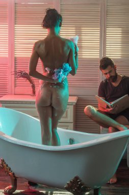 Masaj ve aile spa kavramı. Çıplak kız yıkama iken WISP ile sakallı adam kitabını okudum. Çift banyo ilişkileri köpük ile seviyorum. İki aşık seksi vücut ile. Seks oyunları arzu ve orgazm