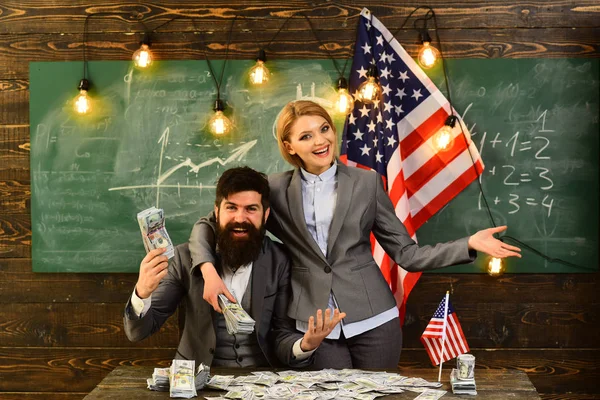 Mężczyzna i kobieta z pieniędzy stojących nad flagą Usa. szczęśliwy i uścisk. — Zdjęcie stockowe