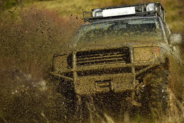 Off road car partecipa alle corse su sfondo naturale. Schizzo di sporcizia sotto SUV sulla strada di campagna. Rally di fondo o di rally raid Extreme e quattro ruote motrici concetto — Foto Stock