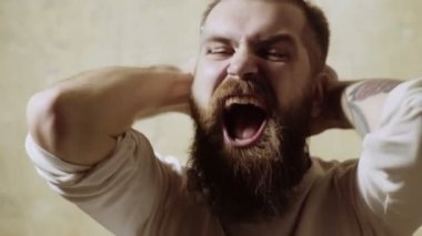 portre kızgın adam ayakta bir duvara yakın ve onun yüzünü kapsar.