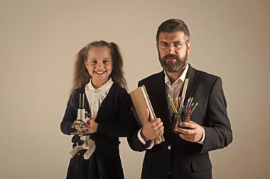 Eğitim ve okul kavramı dön. Çocuk ve öğretmen kitap, kalem ve mikroskop tutun