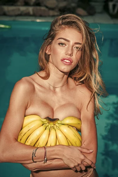 Witaminy dla skóry. Latem basen party portret dziewczynka gospodarstwa żółty pysznego banana egzotycznych owoców, styl życia wegańskie zdrowie, relaks i radość — Zdjęcie stockowe