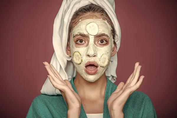 Hud-och hårvård, spa, wellness. Skönhetssalong koncept. Flicka med gurka mask på förvånade ansikte på violett bakgrund — Stockfoto