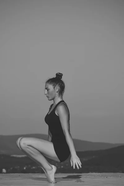 Спортсменка. Женщина-гимнастка в черной спортивной одежде в позе йоги . — стоковое фото
