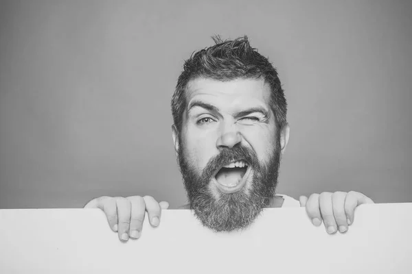 Barbeiro moda e beleza. homem com barba longa no rosto piscando com papel — Fotografia de Stock