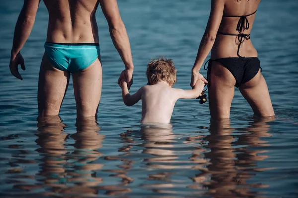 Trust and love as family values. Family travel with kid on mothers or fathers day. Mother and father with son in sea on beach. Child with father and mother. Summer vacation of happy family. — Stock Photo, Image