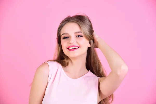Hermosa mujer con el pelo largo posando sobre fondo rosa . —  Fotos de Stock