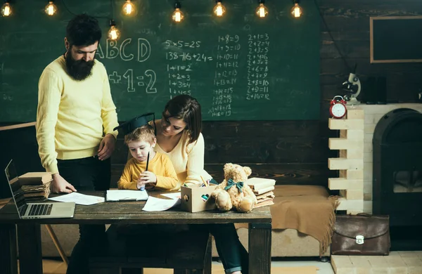 Koncepcja domu. Rodzina troszczy się o edukacji ich syna. Rodziców uczy syna, tablica na tle. Chłopiec słuchanie Mama i tata z uwagą. Rodziców nauczania dziecko, mówiąc — Zdjęcie stockowe