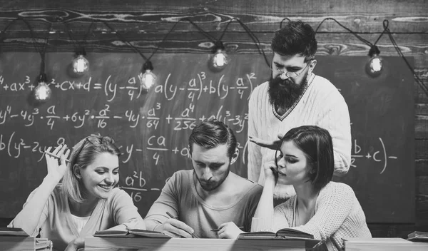 Des étudiants, des camarades de groupe qui parlent, qui demandent conseil, explique l'enseignant. Étude du concept de difficultés. Professeur barbu, conférencier, professeur enseignant aux étudiants, tableau sur fond . — Photo