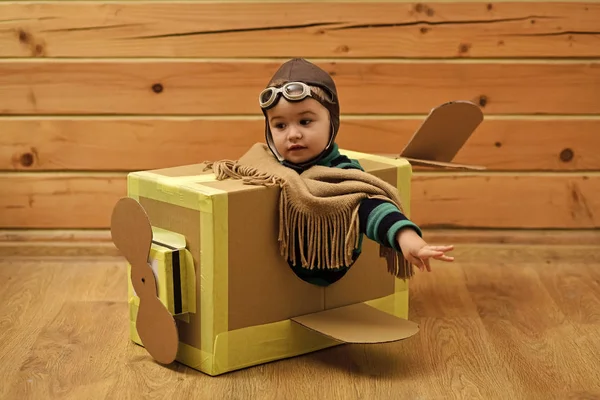 Koncepcja wyobraźni marzenie dzieciństwa. Little cute chłopiec gra z kartonu samolotu. — Zdjęcie stockowe