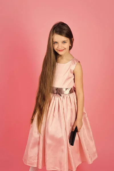 Cuidado de la piel de los niños. Cara de chica retrato en tu anuncio. Niña cepillo de pelo en vestido de moda en rosa . — Foto de Stock