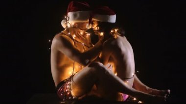 Noel Baba adam ve kız çıplak vücut ile. Noel çift seksi erkek ve kadın aşık. Yeni yıl erkek ve kız arkadaşı siyah izole. Aşk ve sex oyunlar. Kaç ışıklı çelenk içinde ilişkilerin