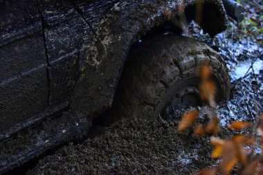 Offroad lastik çamurla kaplı doğa arka plan üzerinde engellerin üstesinden gelir..