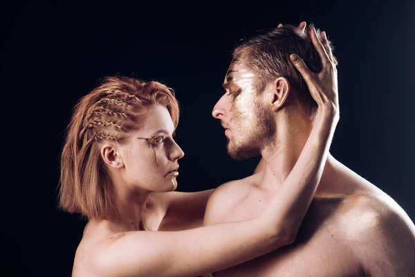 Золотой спа и лечение кожи. Золотая маска и красота коллагена. 24K Gold. Отношения между мужчиной и женщиной. Сексуальная пара с золотым макияжем, изолированным на черном. Эротические игры влюблённых пар
