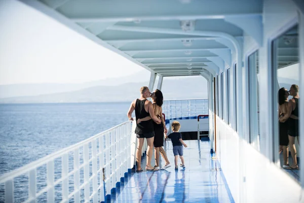 Osoby podróżujące na statek wycieczkowy na słoneczny dzień rodziny i pojęcie miłości. Ojciec, matka i dziecko z morza na tle stać na pokładzie liniowca. Szczęśliwych rodziców Całowanie w pobliżu ładny syna na wakacje — Zdjęcie stockowe