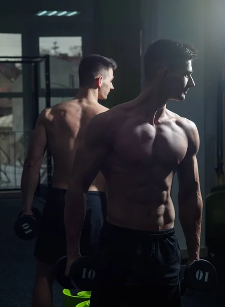 Hombre con torso, macho muscular y su reflejo en el fondo del espejo. Concepto de deporte y gimnasio. Deportista, atleta con músculos se ve atractivo. Hombre con torso desnudo en el gimnasio disfrutar de su estilo de vida deportivo —  Fotos de Stock