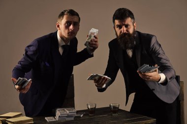 başarılı yatırım. Gizli işlem para ile. Şirket yasadışı iş yapan. Erkekler para ve alkol içecekler yığınları ile masada. Yasadışı iş kavramı.