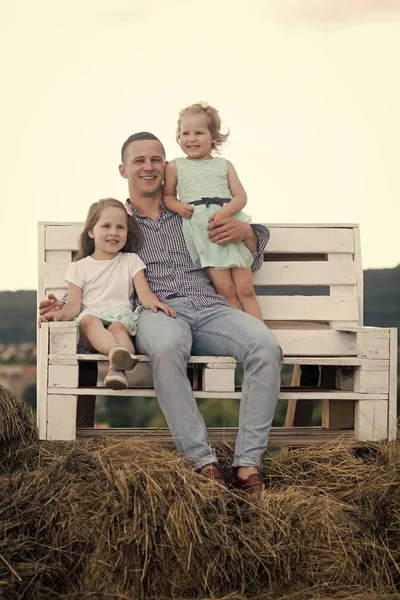 Glücklicher Vater. Mann und Mädchen sitzen auf Bank im Heu — Stockfoto