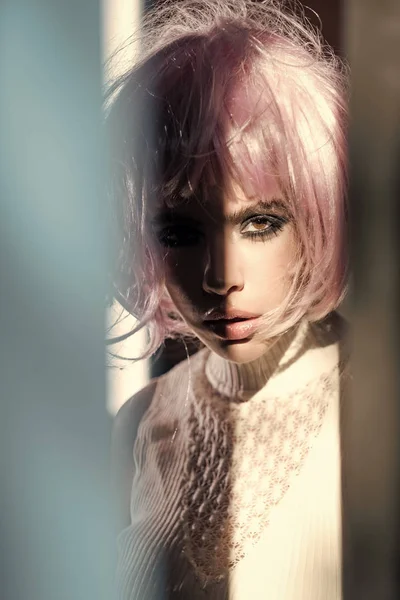 Flicka bära rosa peruk hår med suddiga blå grå förgrunden — Stockfoto
