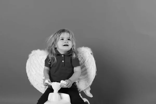 Маленький ангел. ангел-мальчик для приветствия Валентина, счастливый Купидон на автомобильной игрушке — стоковое фото