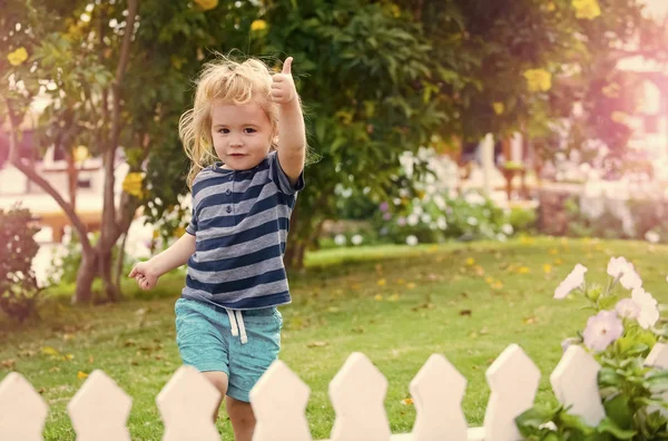 Ευτυχισμένο παιδί διασκεδάζοντας. παιδί ή μικρό αγόρι εξωτερική κοντά σε λευκό ξύλινο φράχτη — Φωτογραφία Αρχείου