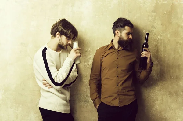 Healthy lifestyle, bad habits, addictive. guy holding milk and bearded hipster with wine