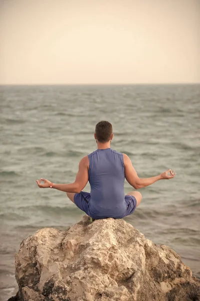 Concepto de armonía. niño practicando yoga cerca del océano azul — Foto de Stock