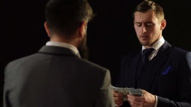 İki erkek kostümleri, para saymak. Gölge ekonomi. Bir adam devlet memuru rüşvet alır.