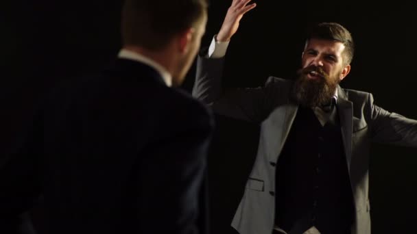 Un hombre con un traje dice emocionalmente y gestos sobre un fondo negro. Gente de negocios . — Vídeos de Stock