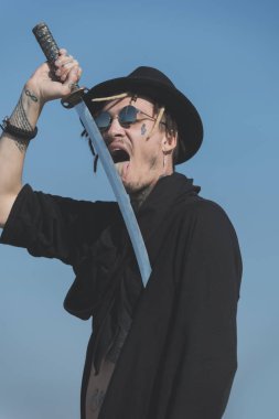 Savaşçı güneş gözlüğü, siyah şapka ve kıyafet