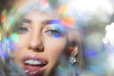 Aydınlık ve parlak görünümlü. Parlak dudaklar ve şehvetli ağız bulanık bokeh arka plan üzerinde olan kadın. Glamour makyaj göz güzellik kız. Yüz cilt bakımı ve sima. Moda ve sanat makyaj