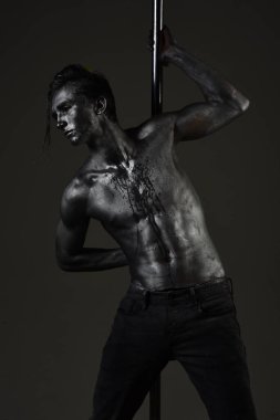 Pilon üzerinde dans gümüş gövde sanat kaslı adam. Pole dans spor. Güçlü dansçı egzersiz kutup. Özgürlük. Metal yüzey ile seksi maço. Atletik adam olun akrobatik öğeleri pilon üzerinde